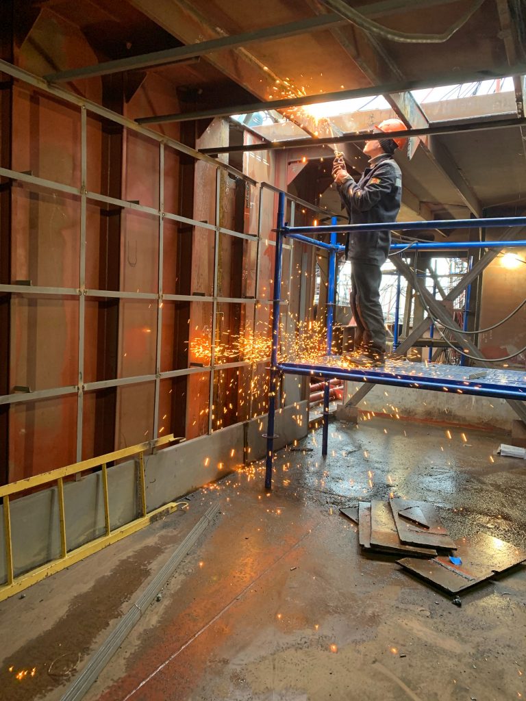 man welding in an industrial building