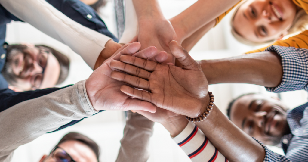 Employees hands in a circle signifying team work